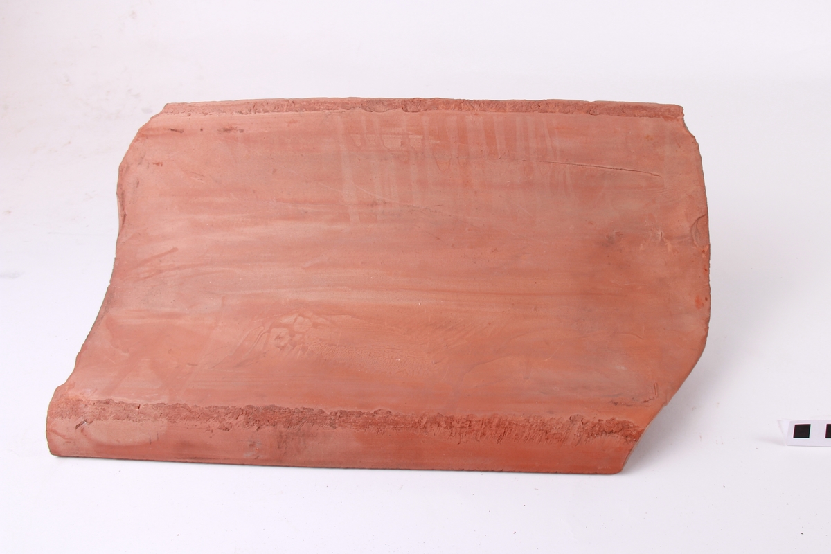 Krum takstein, maskinstrålte. Avskjering for panneknappen på baksida. Dette er den mest vanlege type takstein.