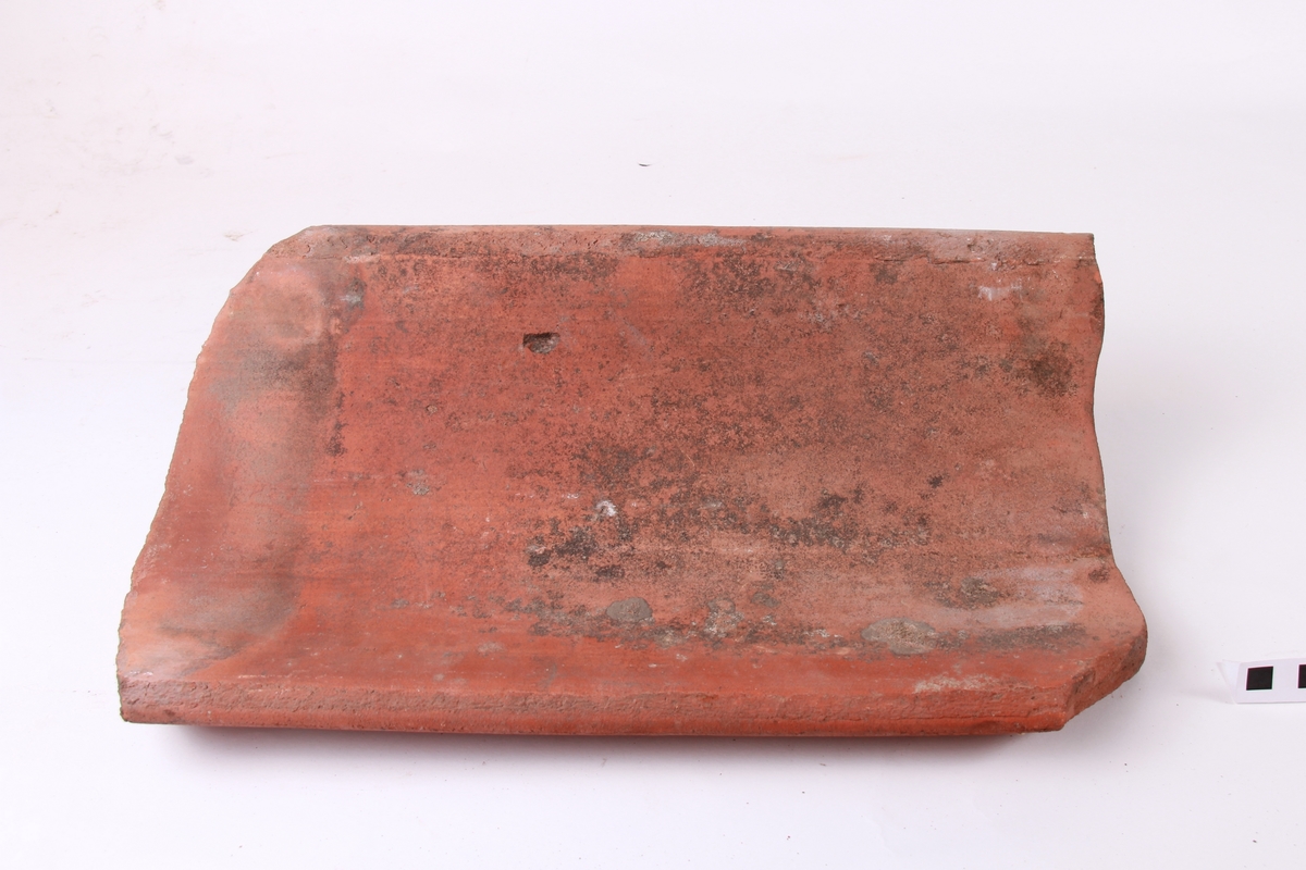 Krum takstein, maskinstrålte. Avskjering for panneknappen på baksida. Dette er den mest vanlege type takstein.