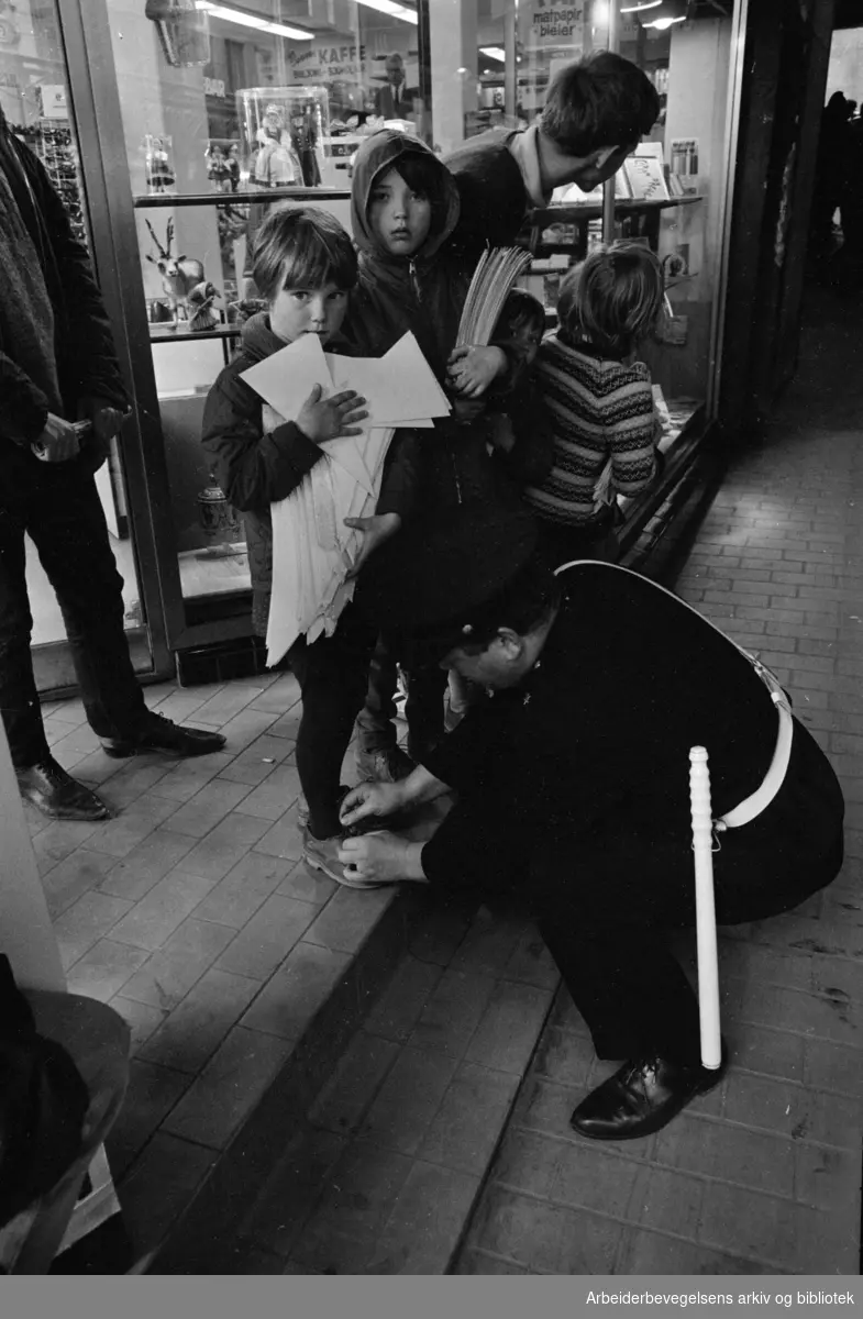 "Strøket". Lille Grensen. Politikonstabel hjelper Berit Svendsen med å knyte lisser. Mai 1967