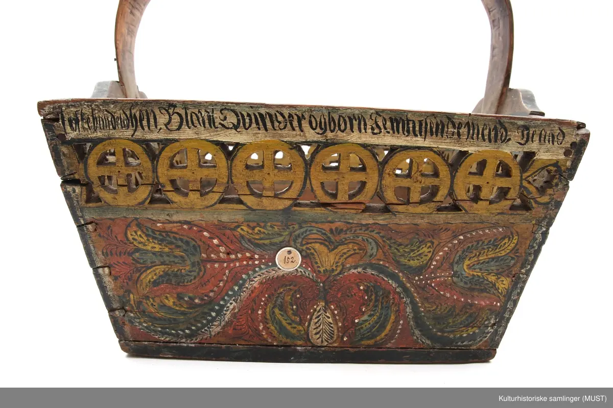 Firkantet kurv i tre med håndtak og dekorasjon.