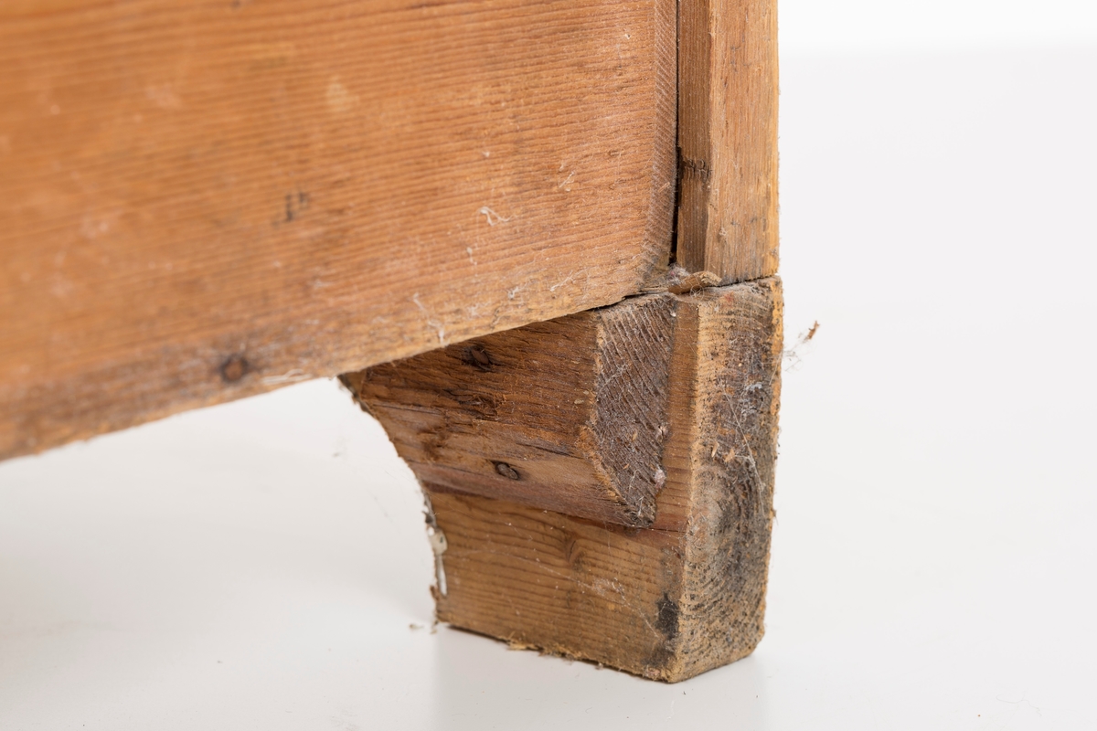 Toalettbord i ubehandlet tre. Det er rom for vaskebolle og skap under. Messingknott på døra til åpning og lukking, spor på innersiden av skapet kan tyde på at det tidligere også har vært en lås.