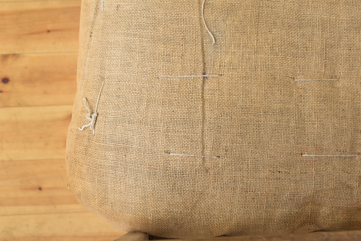 Sengeramme med sangegavler bestående av staver. Ubehandlet tre. Avstivere i metall. Nettingbunn.