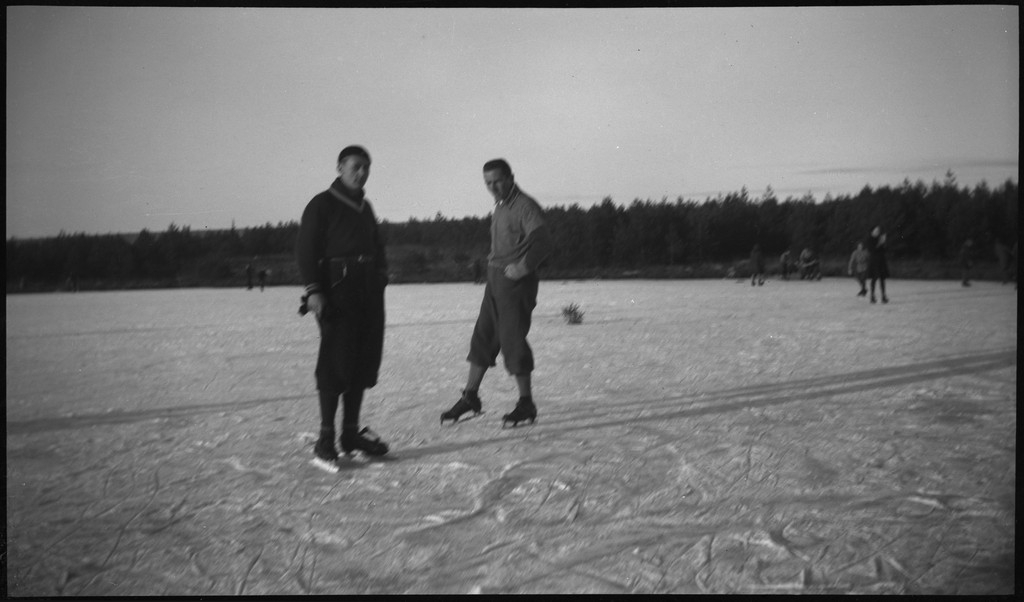 Lindtner og Finn Johannessen med en familie på skøytetur på Gisketjørn i Sandnes. Barna spiller bandy eller ishockey med hjemmelagde køller.