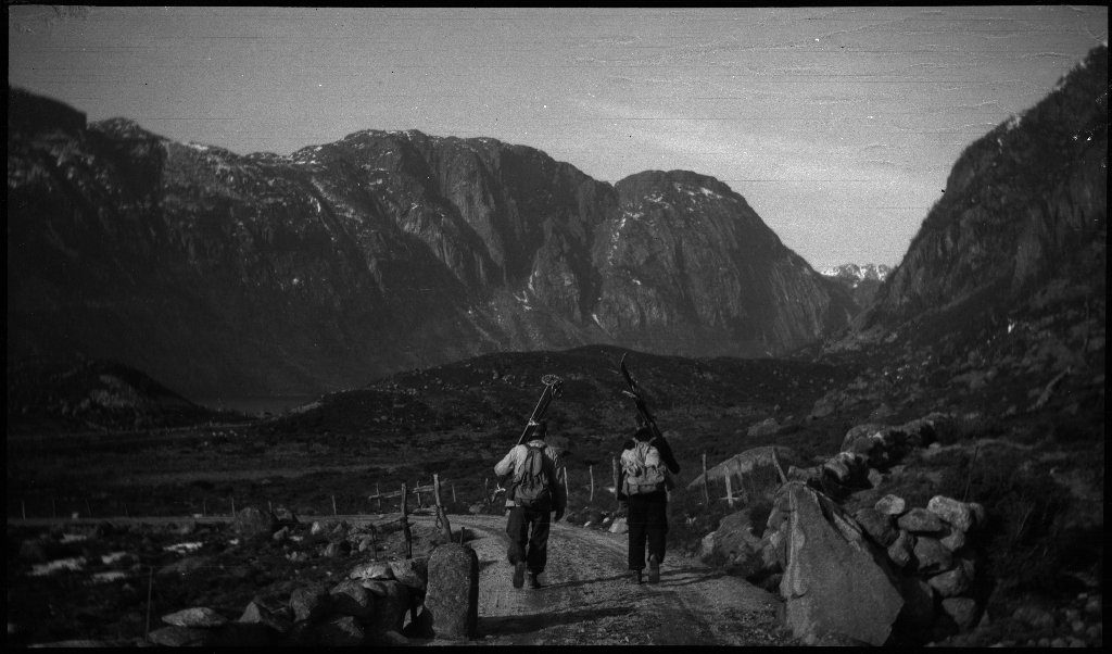 Finn Johannessen, Lindtner og Arne Johannessen ved en gård, og ved noen berg før eller etter en skitur ved Oaland i Forsand kommune. Det er også bilder av Lindtner og Arne Johannessen som bærer skiene på ryggen nedover en bakke.