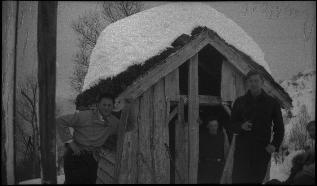 En guttegjeng på skitur i fjellene ovenfor Saudasjøen. Det er bilder av gjengen som går oppover bakkene, og fra en pause ved en gammel hytte.