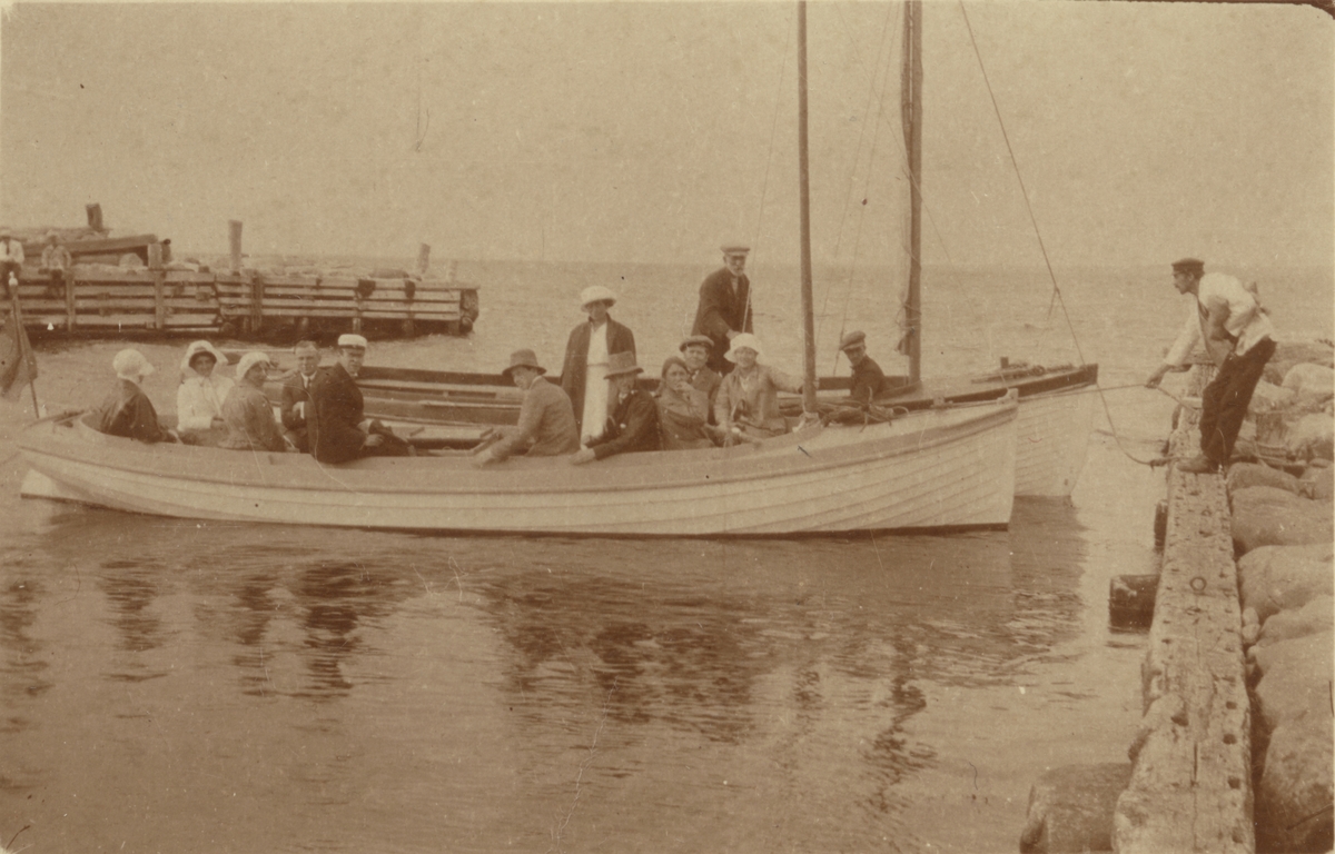 Sällskap i segelbåt, angör brygga i Göteborg. Amatörfotografi från omkring 1905.