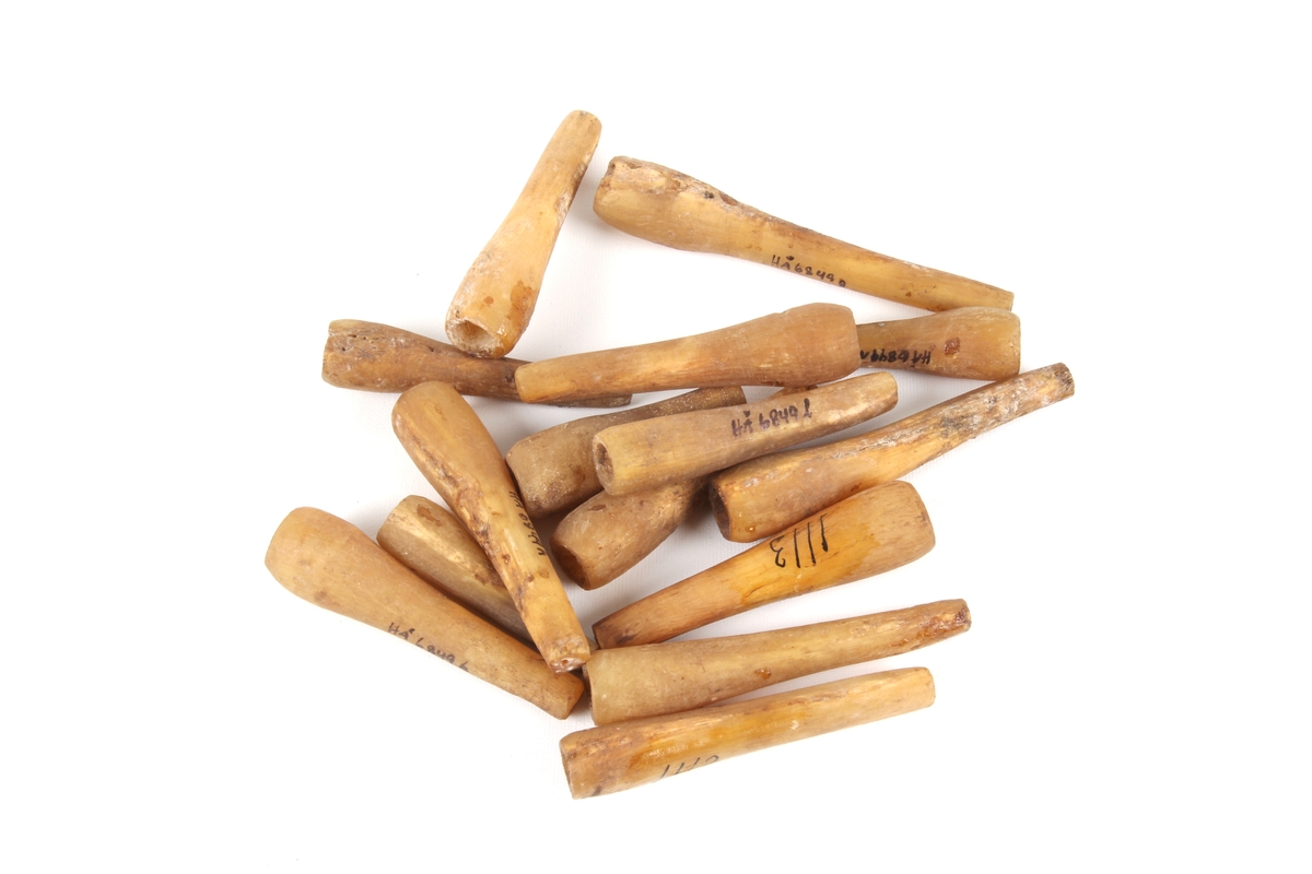 Femten ganske like kniplepinner laget av horn.