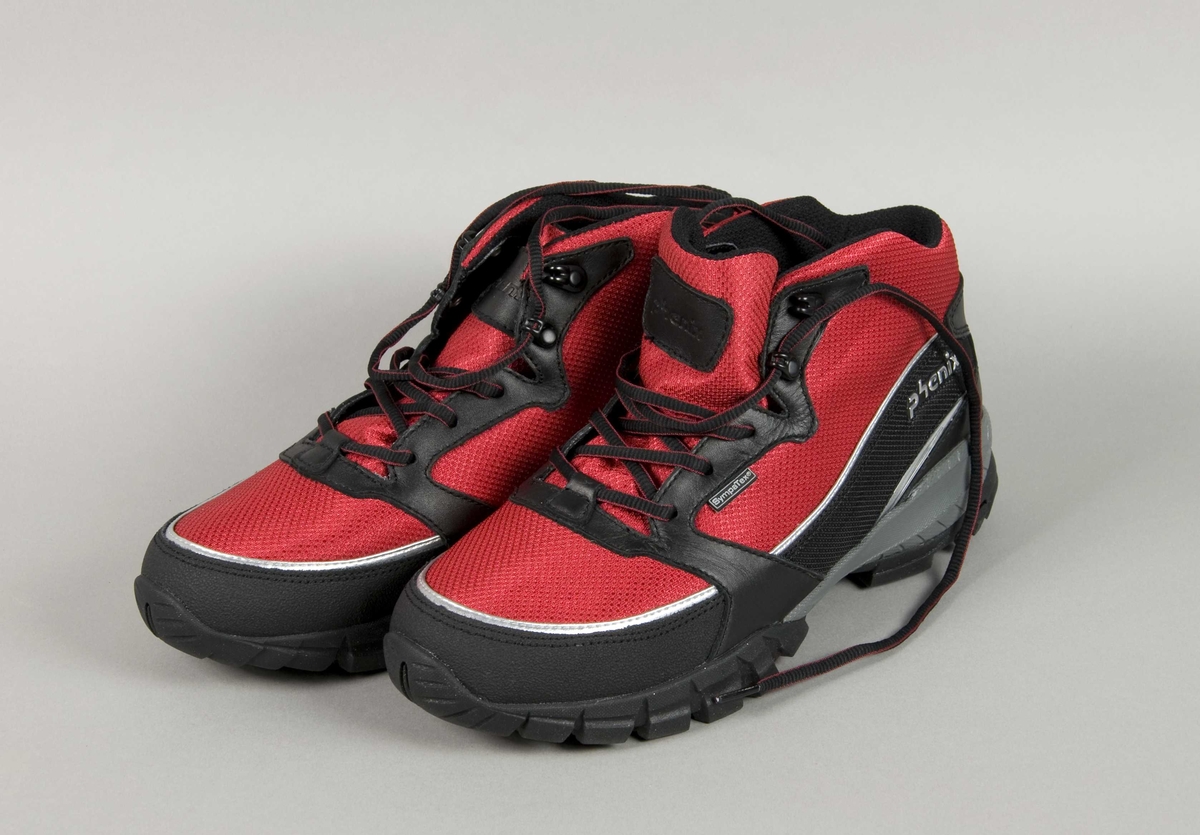 Røde og sorte sko med kraftig gummisåle. Det er to Phenix-merker på skoene.