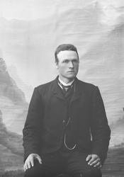 Mann sitter på stol. Nevnt som Nils H. Liene