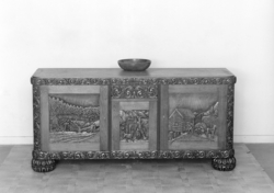 Skap med utskorne motiv på dørene.