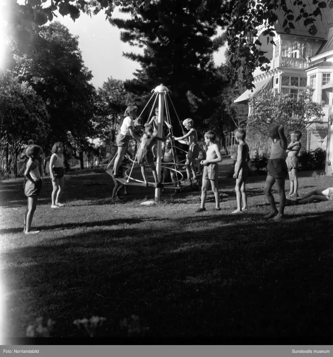Sommarkoloni vid Karlsviks herrgård med barn från Kiruna på besök. Barn som leker i trädgården och gruppfoton.