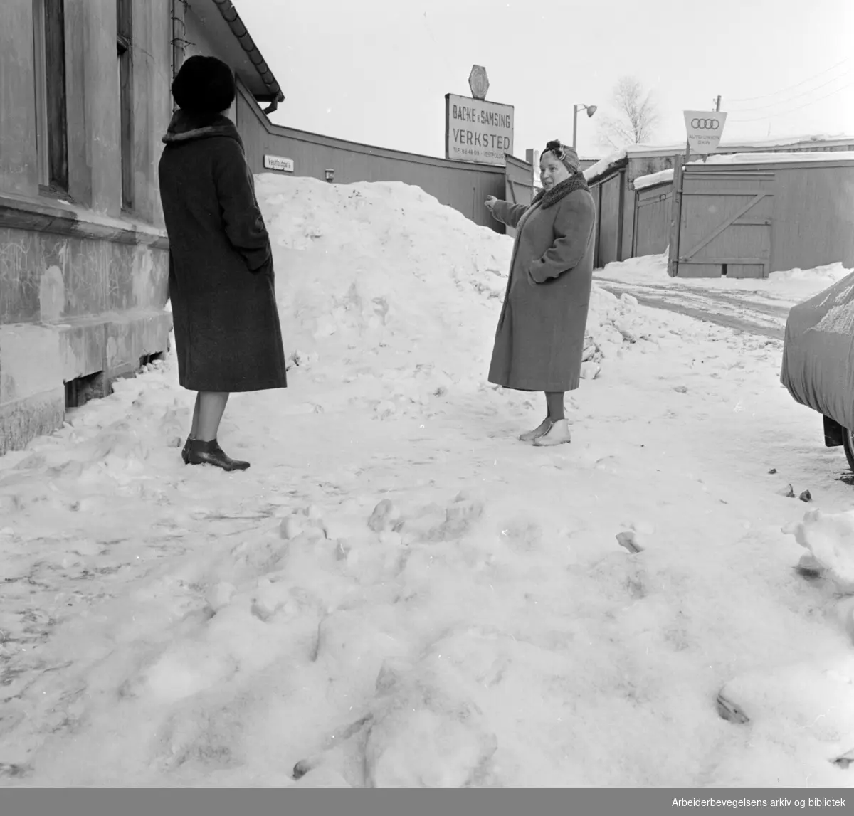 Vestfoldgata. Fru Bjerke og fru Stoltenberg viser hvordan snøbrøytingen foregår på stedet. Februar 1963