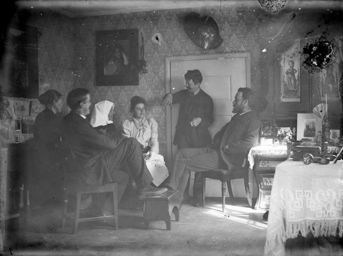 Seks personer i stuen på Skoug gård, Erik Skoug til høyre