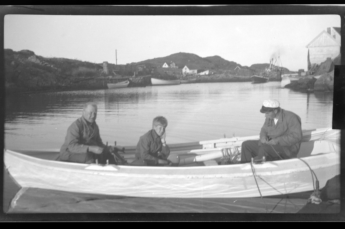 Finn Sundt, Rolf Sundt jr. og Erling Rune sitter i en robåt mellom Holmen og hytten Rune i Farsund.