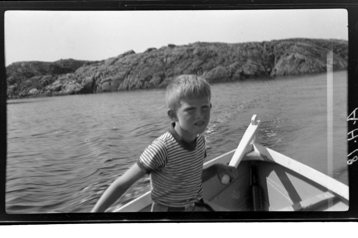 Lars Peter Sundt styrer en robåt, Farsund. Fotografert 1938.