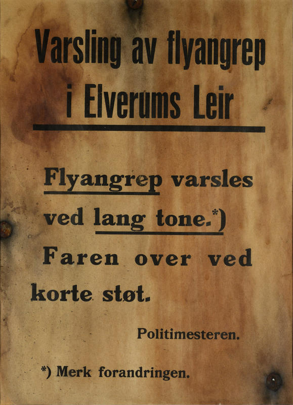 Plakaten blir hengt opp på en bjørk i Elverum sentrum for å varsle befolkningen. Den er tydelig merket av bombingen i 1940. Plakat utlånt av Marit Hjorth Høivik. (Foto/Photo)