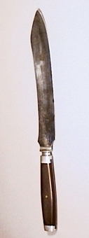 Kniv med handtag av ebenholtz och ändbeslag av stål. Handtagets delar nitade till tången med mässingnitar.