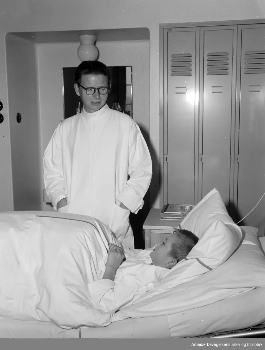 Rikshospitalet. Interiører fra avdeling for plastisk kirurgi..Overlege Willhelm Loenneeken på visit hos 7 år gamle Boye. Oktober 1953.