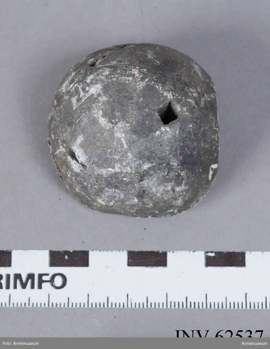 Grupp F II.
Mindre kula av sten och bly. Fragment av en med bly omgjuten flinta, funnen på Gotland. Äldre Vasatid.