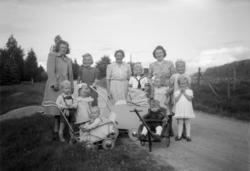 Foto av tre kvinner sammen med en gruppe barn. Kan være fra 