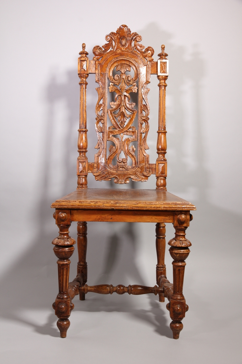 Matsalsstol, 2 st, av betsad ek. Nyrenässans stil med profilsvarvade ben och rygg i genombrutet arbete. Sitsen har ett pressat mönster föreställande en maskaron.