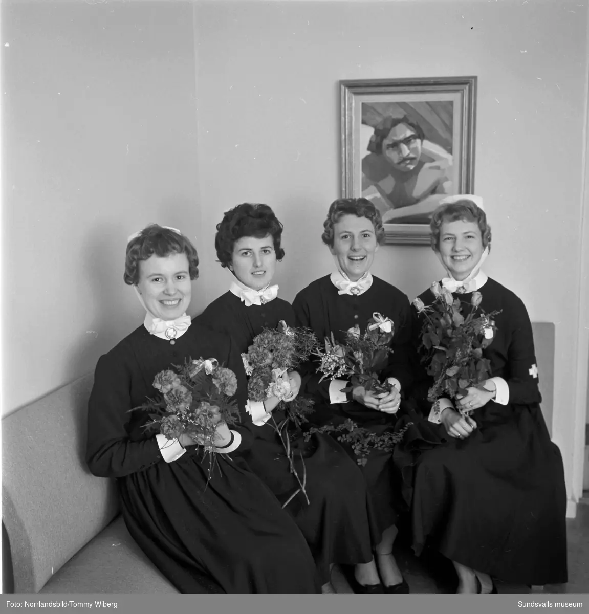 Sjuksköterskeinvigning, fyra färdigutbildade sköterskor med blombuketter.