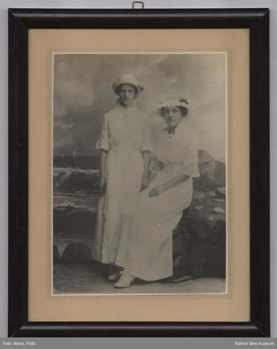 Tvillingsystrarna Ruth och Signe Kullzén, i långa ljusa klänningar och med huvudbonader.