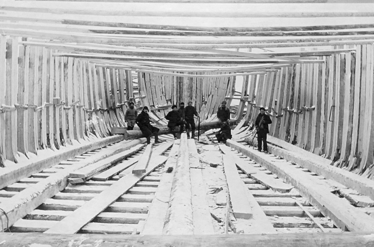 Bygging av lekter, antakelig i nærheten av Onega i Nordvest-Russland, tidlig på 1900-tallet.  Fotografiet er tatt inne i det som skulle bli en flatbotnet, forholdsvis stor båtkonstruksjon på et tidspunkt da båtbyggerne hadde fått på plass spantene – båtens skjelett – men ikke hudplankene.  I den fremre delen av båten ser vi åtte mannspersoner, antakelig arbeidslaget som lagde denne lekteren.

Egil Abrahamsen (1893-1979), som fra 1911 arbeidet ved et sagbruk drammensfirmaet Bache & Vig var i ferd med å etablere i Onega, forteller i sine erindringer følgende om funksjonene til disse lekterne:

«Nå begynte en for meg ny operasjon, som det var interessant å lære.  Forholdet var det at elven var bred og dyp hos oss ved bruket, men grunnet opp med en «bar» (sandbanke) like før den forener seg med havet.  Derfor måtte havgående dampskip som stakk mer enn syv og en halv fot, kaste anker utenfor baren i det åpne havet og all last sendes ut med lektere.  Walstad [disponenten ved Bache & Wigs sagbruk i Onega] hadde ordnet med byggingen av disse lekterne, åtte stykker, store, sterkbyggede trelekere, 120 fot lange og 30 fot brede, som kunne ta opptil 110 standards last (350 tonn).  Han hadde kjøpt to slepebåter til å buksere disse.  For å holde lastingen gående uten stans og demurrage (godtgjørelse for overligging, tid da fartøyet ble liggende på vent for lenge i henhold til kontrakt med rederen), måtte en dampbåt med fire vinsjer ha to slike lektere annenhver dag.  Stuerne reiste med den første lekteren og forble om bord til båten var ferdiglastet.  En vanlig trelastbåt på den tiden var 2 500 tonn som tok 600-700 standard, og mange var norske.  Stuerne kokte sin egen mat om bord, sov i rommene eller på dekkslasten og som tidsfordriv underholdt de mannskapet med sin flerstemmige sang, oftest sørgmodige melodier om siden og fedrenes lidelser, men de hadde jo også sine lystige sanger.  Kapteinene fortalte at de var imponert over tempoet disse folkene holdt og over at de var villige til å arbeide til langt på natt, hvis det var last langs skutesiden.  Dette satte kapteinene pris på fordi ikke hver dag var arbeidsdag; ble det nordlig eller nordvestlig kuling, kunne ikke disse store lekterne ligge langs skutesiden, men måtte ankres opp akterut, og certepartiet lød på working days weather permitting, så uvær var derfor skipets tap. …» 

Egil Abrahamsen forteller også om bemanninga av lekterne:

«Jeg har glemt å notere at i slutten av mars fikk jeg et spesialoppdrag av Walstad [disponenten].  Det måtte langveis fra skaffes fem lag a 38 mann, sesongarbeidere – stuere til å arbeide om bord i båtene.  Spesialister på dette området kunne man forhyre i noen store, men ensomt beliggende landsbyer.  Disse lå efter hverandre utover den store halvøen som stikker ut i Hvitehavet mellom Onega og Arkhangelsk.  Den nærmeste lå 20 kilometer og den ytterste 150 kilometer borte, kanskje mer.  Der var ingen vei eller telefon.  Folkene, som var jegere og fiskere om vinteren, kunne ta sesongarbeide om sommeren.  Til hvert lag skulle jeg finne og forhyre en bra, ordentlig mann til bas, «head man», som engelskmennene sier.  Jeg dro av gårde med en hest alene langs Hvitehavets strandkant på vårisen, som da var ganske blank.  Solen hadde tatt snøen.  Hver gang jeg så tegn til en landsby, svinget jeg av dit.  Jeg kom derved på denne turen opp i noen forunderlige gammeldagse samfunn, men fant folkene vennlige og gjestfrie, dypt religiøse, de såkalte «starovery», det er gammeltroende.  Det var en sekt, eller rettere sagt, det var efterkommere av den opprinnelige rette ortodokse tro, som i sin tid nektet å ta ved en slags revisjon av læren under en av de store russiske keiserinner.  Jeg tror det var keiserinne Elizaveta, så vidt jeg husker Peter den stores datter. [Dette stemmer ikke helt, Elizaveta levde tidligere enn Peter]  Den russiske historien forteller at da keiserinnens befaling om forandring i læren utkom, var det massevis av folk som nektet å lystre og av skrekk for straff dro fra sine landsbyer i Sentral-Russland og nordover, stadig nordover, til øde, ubebodde trakter.  Efterkommere av disse bodde enda i vår tid ved Hvitehavet å begge sider av Onegabukten.

I løpet av forretningsreisen besøkte jeg den ene landsby efter den annen, og fikk forhyrt de nødvendige 200 mann.  Basene – eller de ansvarlige formenn – måtte utsøkes først, og siden, med deres hjelp, ble folkene tatt ut.  Det var mange flere villige enn jeg behøvde.  Vi skrev høytidelig kontrakt, men de var analfabeter og satte bare sitt bumerke under, men det som for dem var betydningsfullt var ikke kontrakten, men det var at vi alle sammen vendte oss til ikonen og gjorde korsets tegn.  Mange av dem hadde vært i Vardø på fisketur, og sa de likte at jeg var norsk.  De ble våre faste stuere i flere år, men mange falt i den første verdenskrig og i borgerkrigen. …»