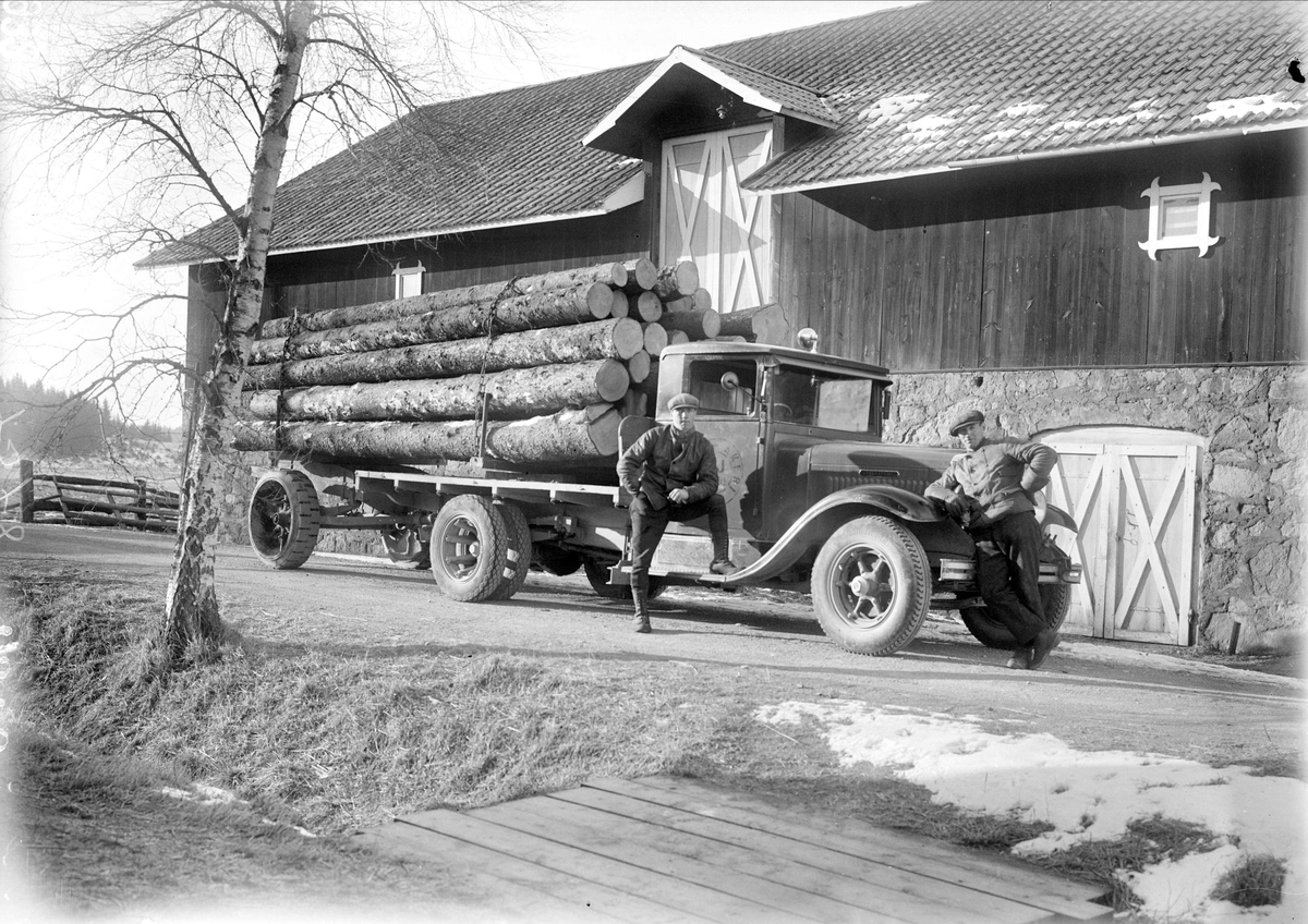 "Sigfrid Hallman med timmerlass på bil framför vår ladugård i Sevasta", Altuna socken, Uppland 1932