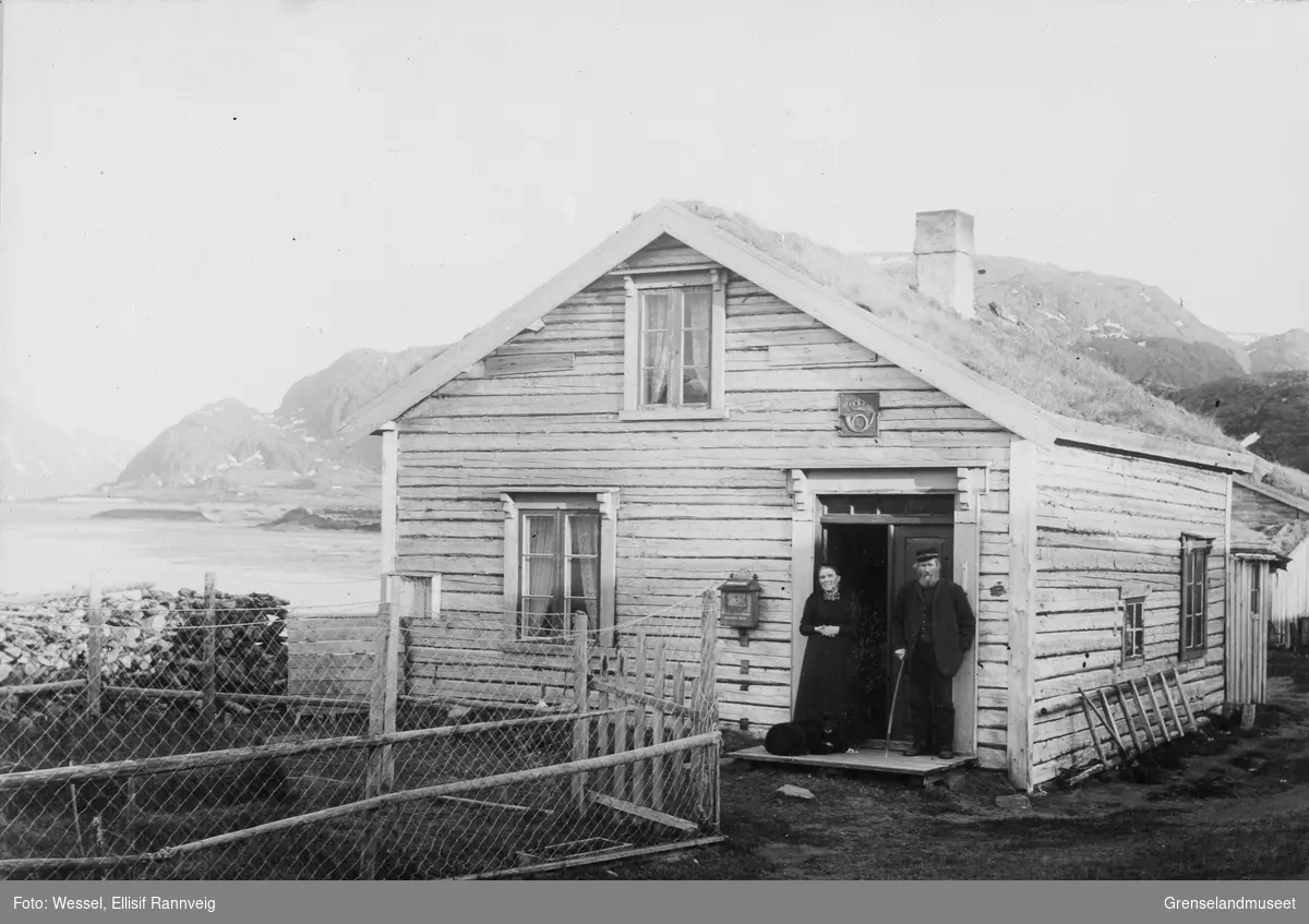 Poståpneri og tollstasjon i Grense Jakobselv. Carl Peder Olson med frue Marthine i døra.