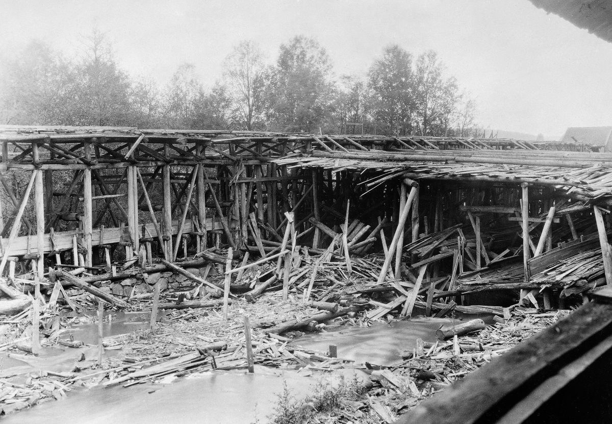 Ruiner av tømmerkjerratanlegget ved Sanne og Soli bruk i Tune i Østfold.  Den nevnte kjerraten besto av en kraftig, endeløs og roterende kjetting, som trakk tømmerstokkene fra vassdraget inn mot saghusene, der de skulle deles opp i planker og bord.  Kjerraten ble drevet av vannkraft.  Da dette fotografiet ble tatt, i 1931 (18 år etter at virksomheten ble avviklet), var særlig denne delen av anlegget i kraftig forfall.  Noe mer informasjon om skurlastproduksjonen ved Solifossen i Ågårdselva finnes under fanen «Opplysninger».
