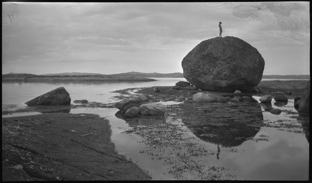 Seile og rotur til Lindøy utenfor Stavanger. Lindtner og en annen ung mann sitter i hver sin båt, en liten seilbåt og en robåt. Det er også bilder fra en stor, rund stein som den ene står oppå.
