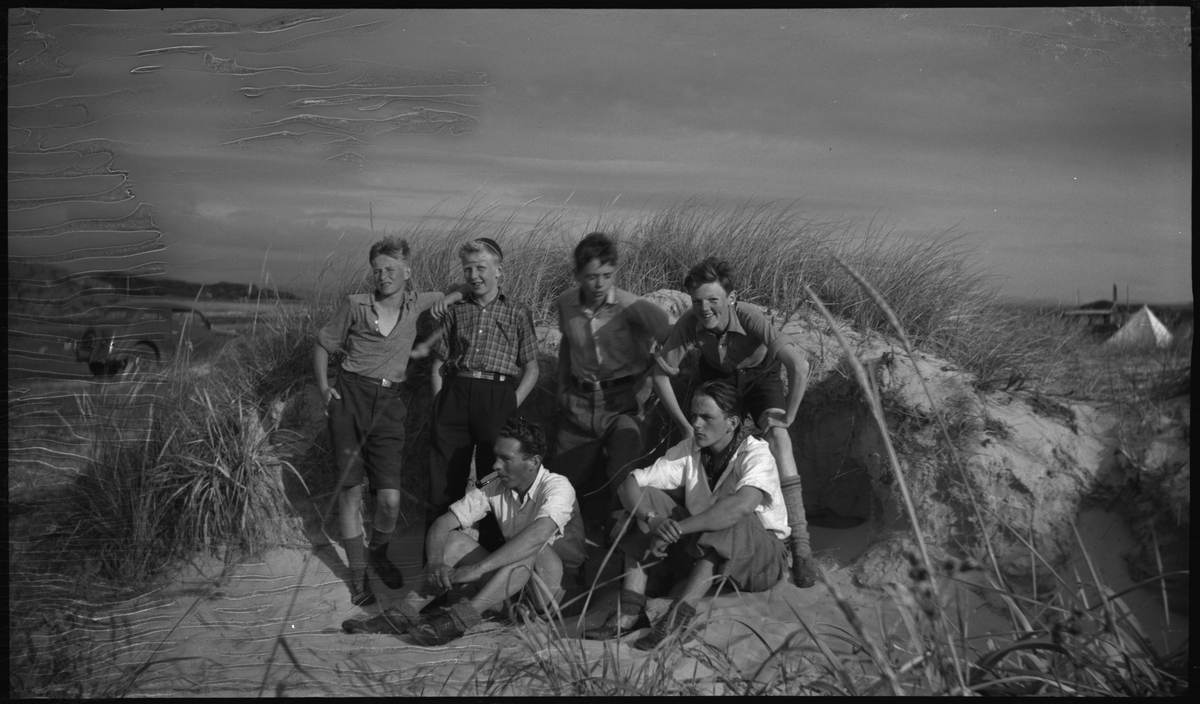 En gjeng med gutter leker ved noen telt og i sanddynene på Solasanden. Lindtner sitter fremme til venstre på bilde nr. fem. En gutt har på en skjorte med "SIF"- merket (Stavanger Idrettsforening).