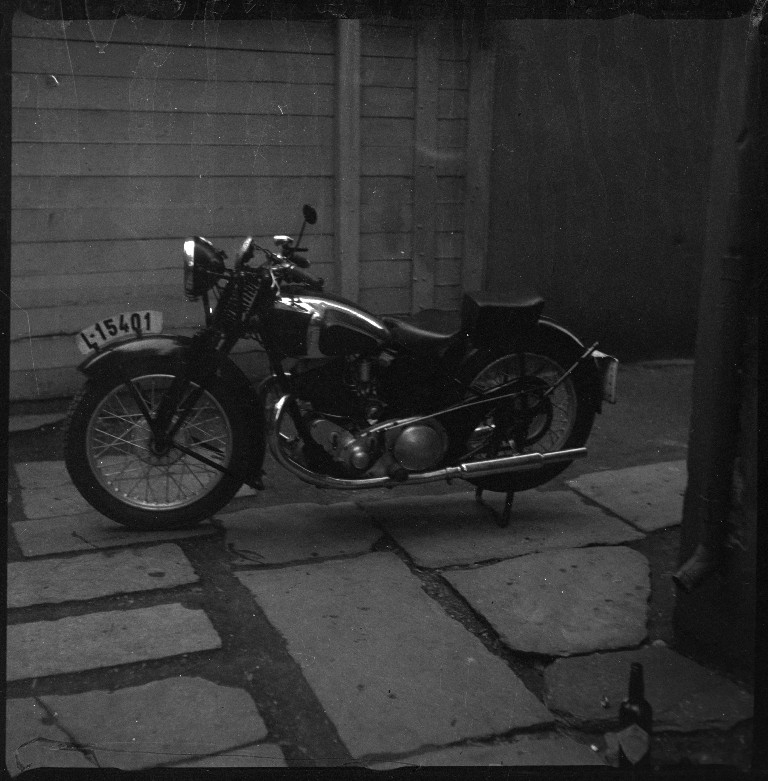 En motorsykkel av merket "Calthorpe" fotografert i en bakgård.