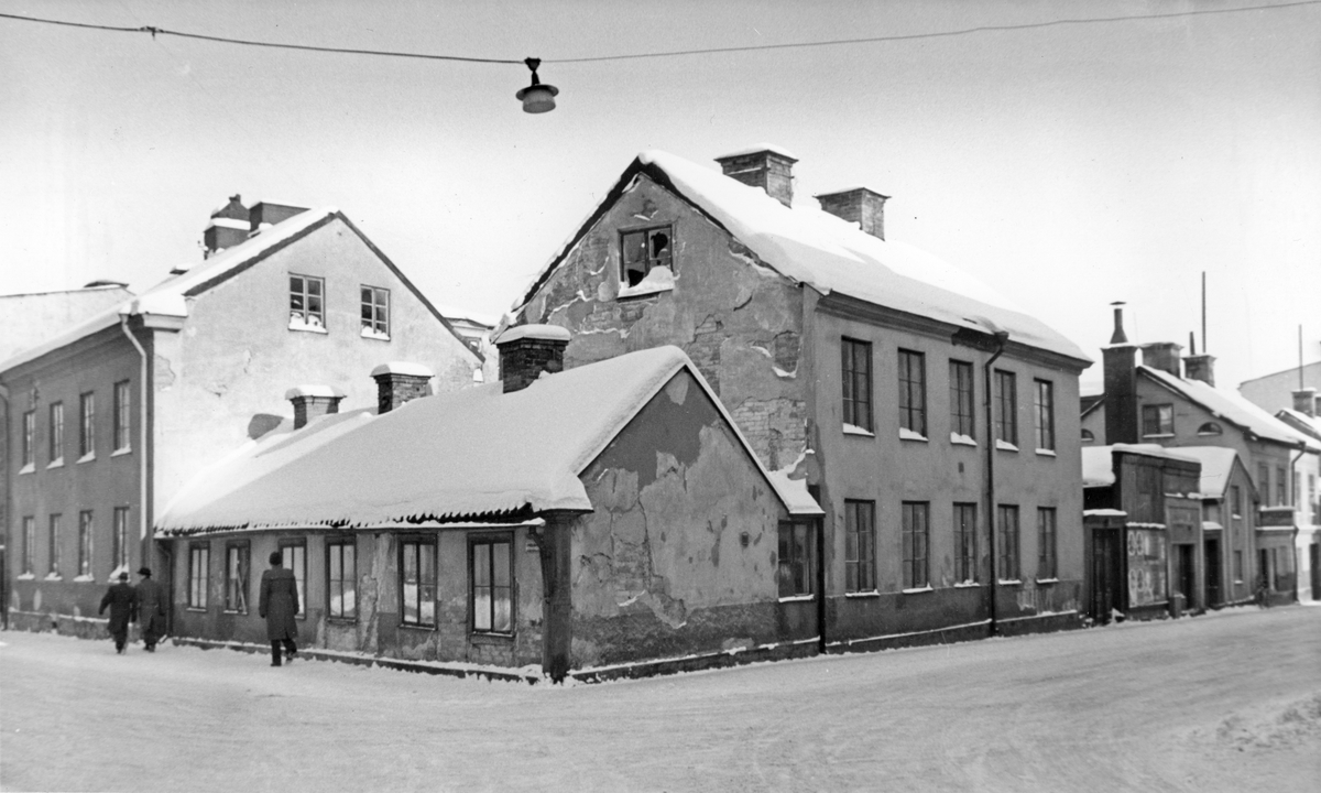 Kvarteret Stenhuggaren, med byggnader från 1800-talet, vid hörnet av Sandgatan och Smedjegatan i Norrköping.
Fotografiet är taget 1956 i samband med rivningsansökan. Vy mot nordost.