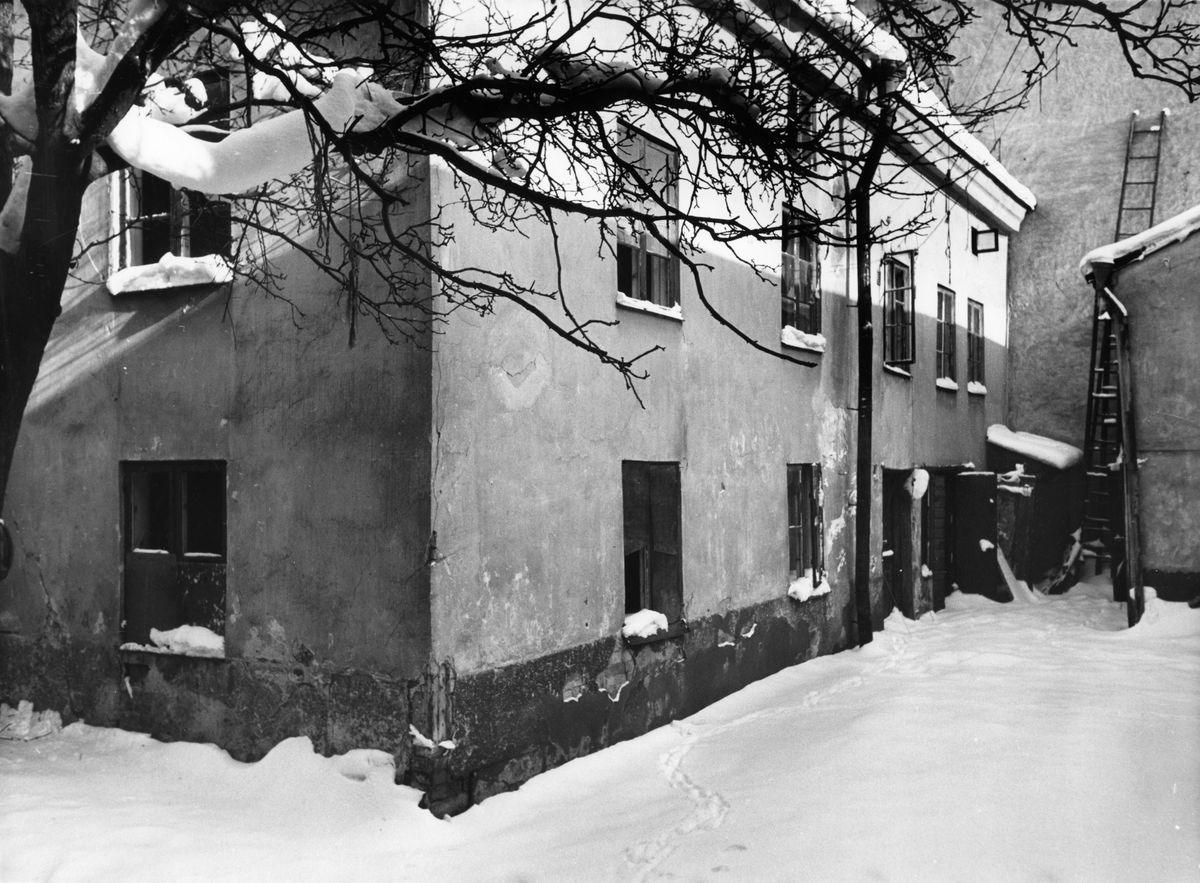 Gårdsvy från kvarteret Stenhuggaren i Norrköping. Bilden visar gårdshus till fastighet nr 7. Fotografiet är taget 1956 i samband med rivningsansökan. Byggnaden var i tre våningar. Den rymde tre enrumslägenheter med kök, en större lägenhet på översta våningen och tvättstuga med förråd på bottenvåningen. Vy mot nordost.