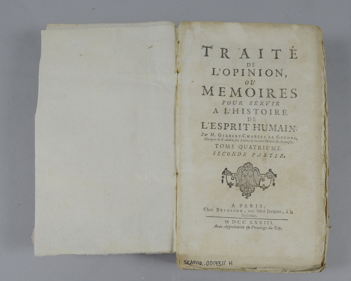 Bok, häftad: "Traité de l'opinion, ou mémoires pour servir à l'histoire de l'esprit humain ", skriven av Gilbert Charles Le Gendre, utgiven i Paris 1733. Vol. 4, andra delen. 
Pärmen klädd i marmorerat papper, i vitt, rosa och grönt. Med oskurna snitt. Ej uppsprättad. På ryggen påklistrade pappersetiketter med titel (oläslig) och volymnummer.