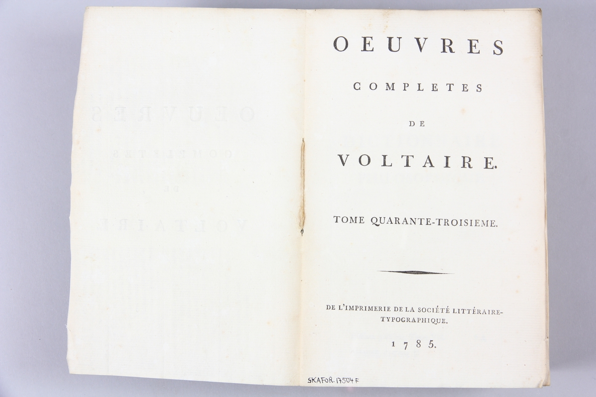 Bok, pappband,"Oeuvres complètes de Voltaire." del 43, tryckt 1785.
Pärm av gråblått papper, på pärmens insidor klistrade sidor ur annan bok. Med skurna snitt. På ryggen pappersetikett med tryckt text med volymens namn och nummer. Ryggen blekt.