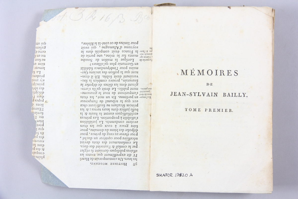 Bok, pappband, "Mémoires de Jean-Sylvain Bailly", del 1, tryckt 1804 i Paris. Pärmar av gråblått papper, blekt rygg med tryckta etiketter. Klistrade sidor ur annan bok på pärmarnas insidor. Skuret snitt.
