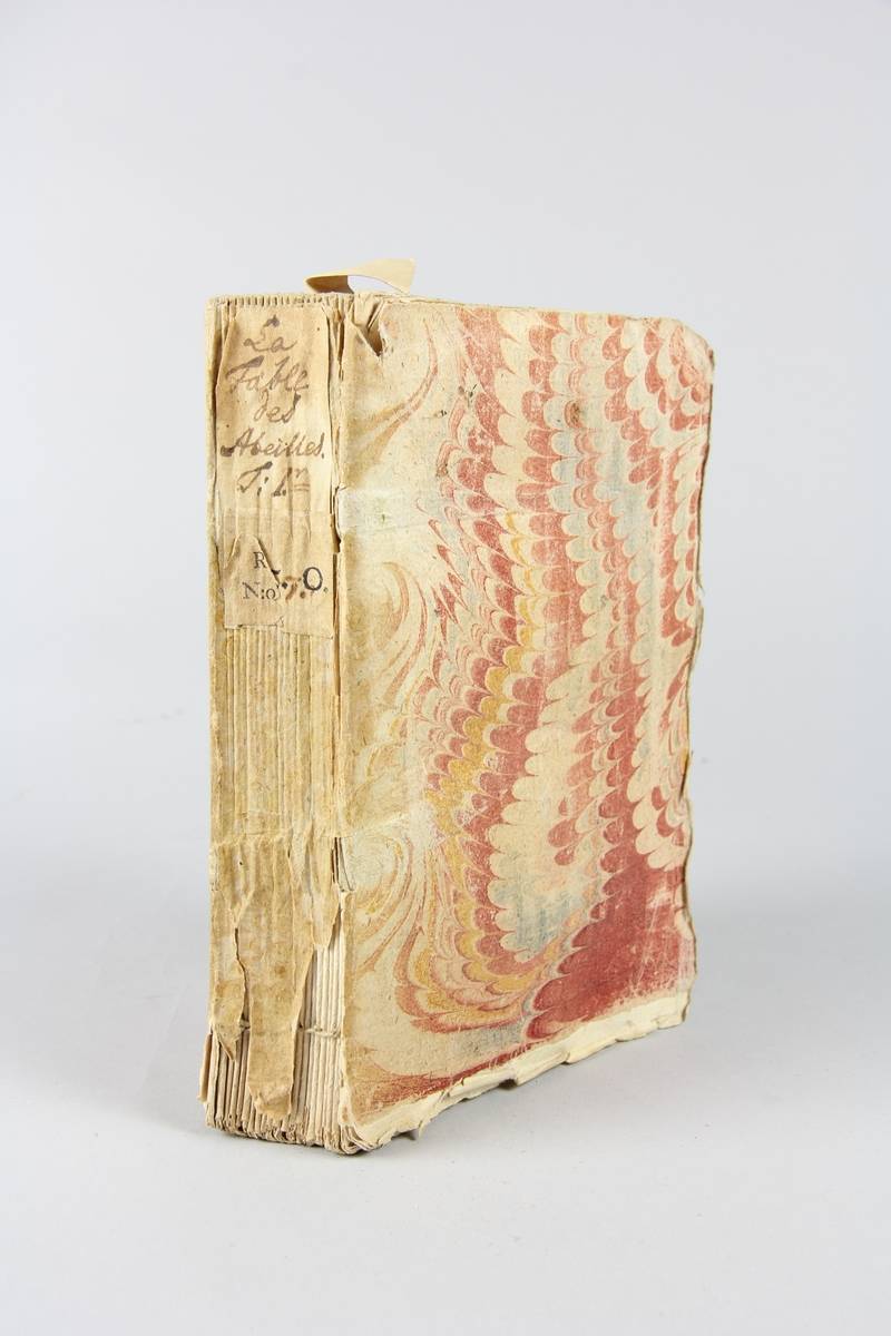 Bok, häftad, "La fable des abeilles, ou les fripons", del 1, tryckt i London 1740.
Pärm av marmorerat papper, oskurna snitt. På ryggen klistrade pappersetiketter med volymens namn och samlingsnummer. Ryggen blekt.
