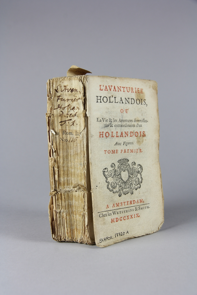 Bok, häftad, "L´avanturier hollandois", del 1. Pärmar av marmorerat papper, oskuret snitt. Rygg med pappersetikett med bokens titel och samlingsnummer. Illustrerad med kopparstick. Främre pärm saknas.