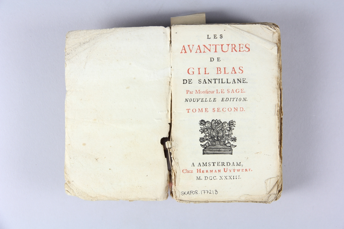 Bok, häftad,"Les avantures de Gil Blas", del 2, tryckt i Amsterdam 1733. Pärm av marmorerat papper, oskurna snitt. På ryggen klistrad pappersetikett med volymens namn och samlingsnummer. Ryggen blekt.