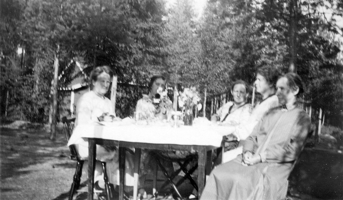 Kvinnor kring kaffebord utomhus.Tidigt 1900-tal.