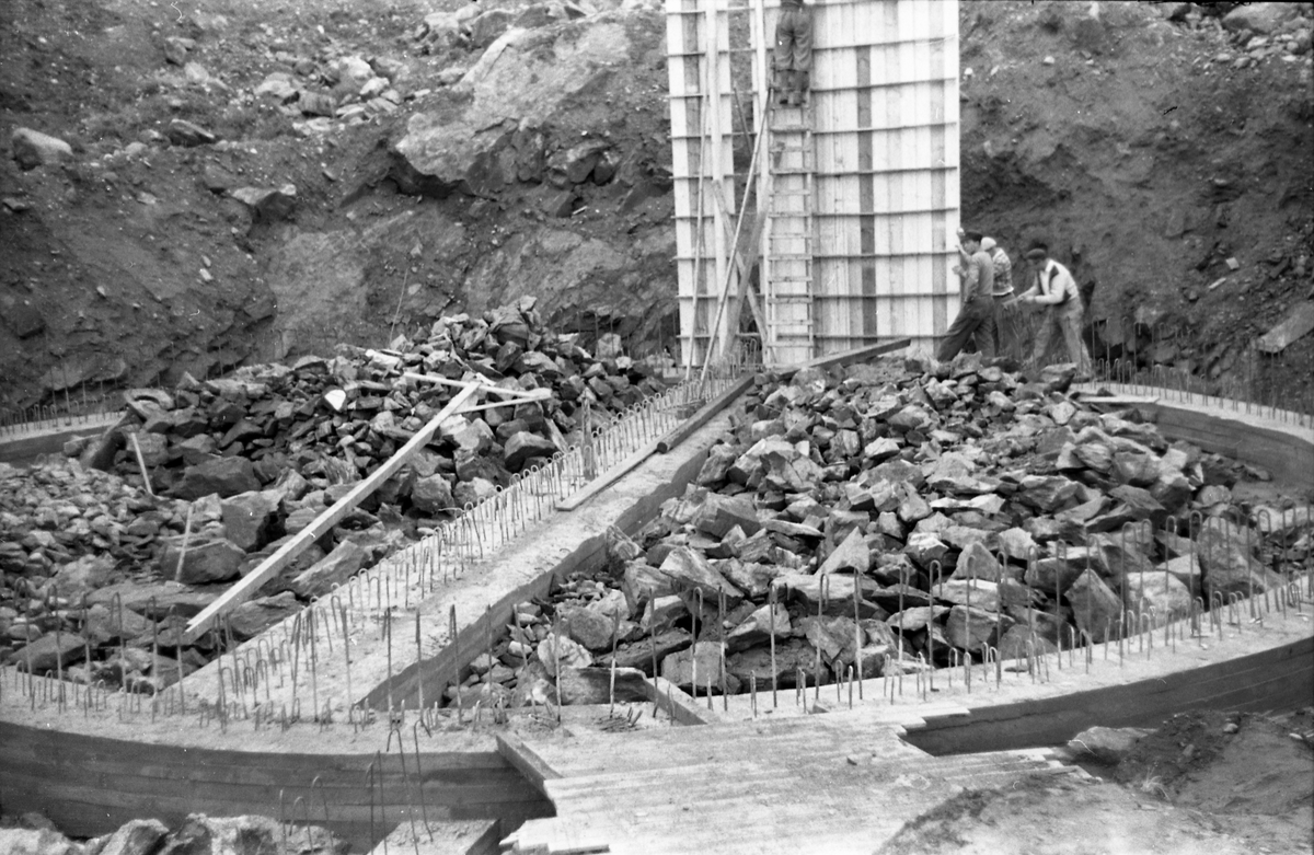 Trolig fra bygginga av Skreia Vannverks basseng i Sluken ovafoir Skreia,september 1953. Mennene er ikke identifisert.
