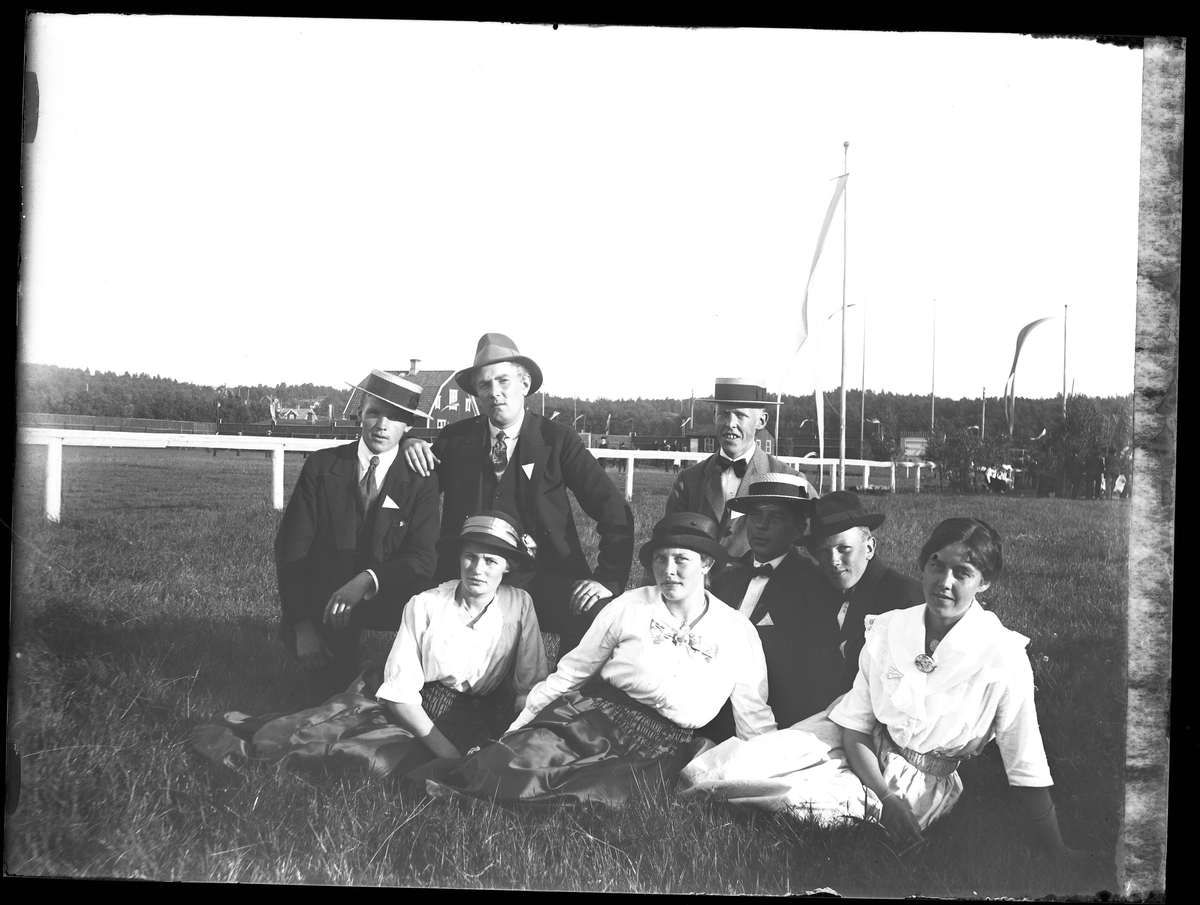 Gruppbild på fem män och tre kvinnor vid idrottsplatsen. I fotografens beskrivning står det "Hallgren mfl"