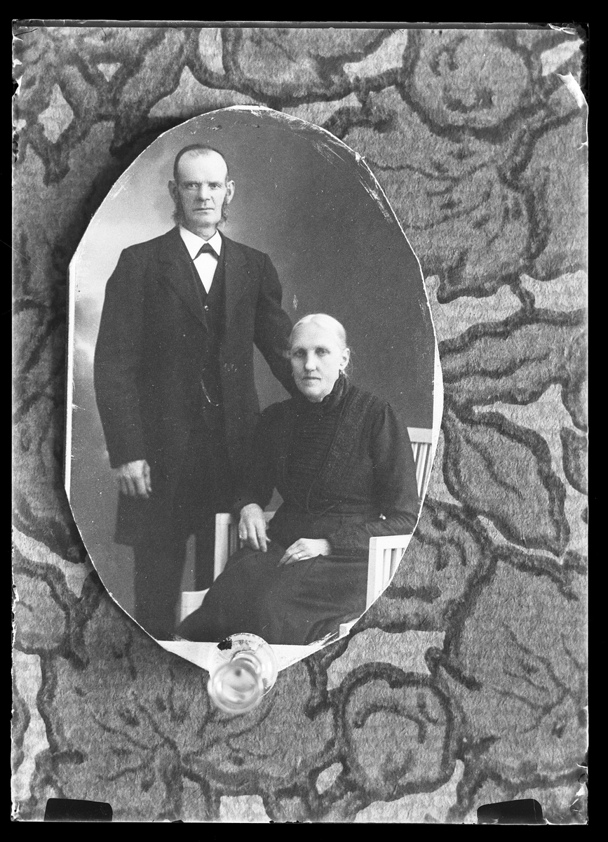 Reprofotografi av porträtt på ett äldre svartklätt par. I fotografens egna anteckningar står det "Rep. för Hj. Nilsson". Tolkat som Hjalmar Nilsson.
