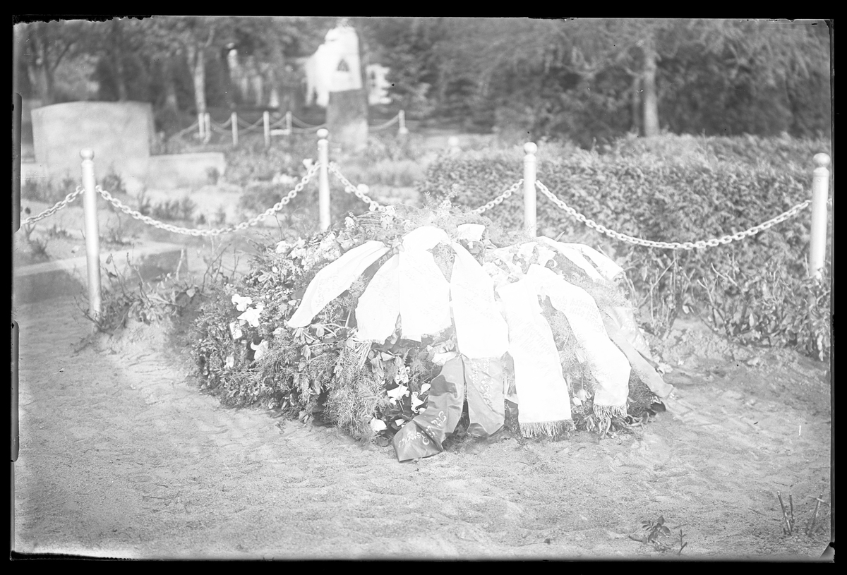 Bengt Nilssons grav täckt av blommor och band.