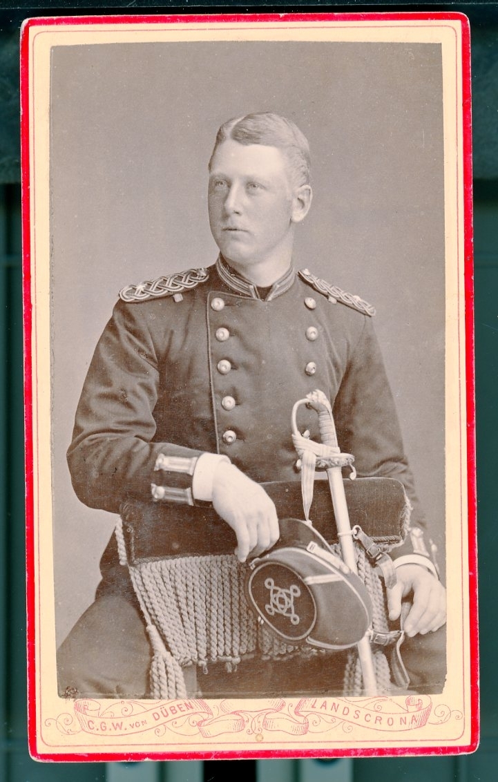 Kabinettsfotografi: Gustaf Wrangel i uniform sittande bakvänd på stol med blicken i fjärran. En ung man.