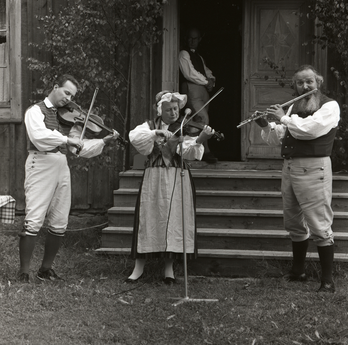 Under hembygdsfesten i Rengsjö spelar tre personer fiol och flöjt under ett uppträdande, 16 juli 1961.