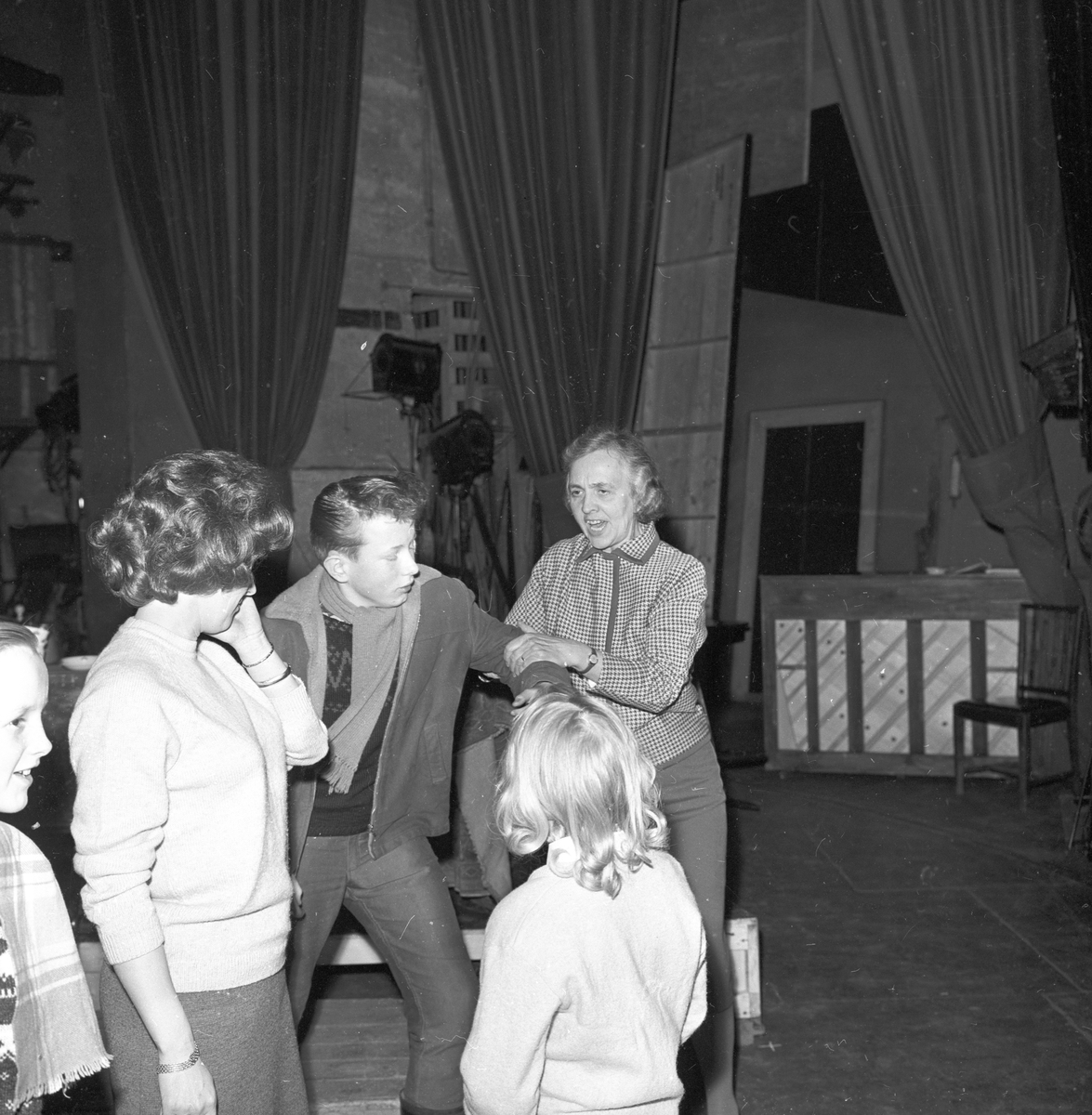Antagelig fra prøver på oppsetning av musikalen "Trost i taklampa". Sølvi Wang og en dame med flere barn på scenen. Fotografert mars 1963.